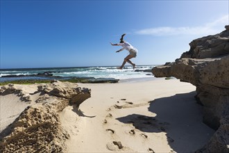 Girl jumping off rock