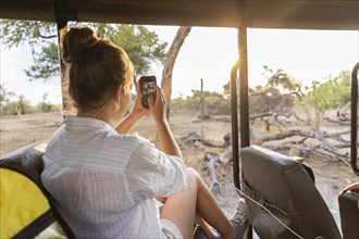 Girl in safari vehicle taking pictures