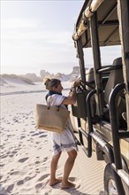 Woman unloading luggage off safari vehicle in Walker Bay Nature Reserve