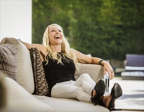 Woman laughing on sofa