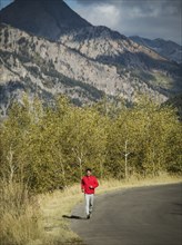 Man jogging on mountain road on sunny day