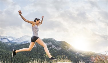 Woman jogging in mountain landscape at sunset
