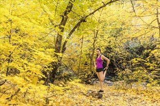 Woman stretching in Autumn forest