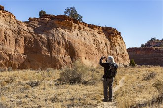 Senior hiker photographing rock formations
