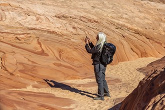 Senior hiker photographing rock formations