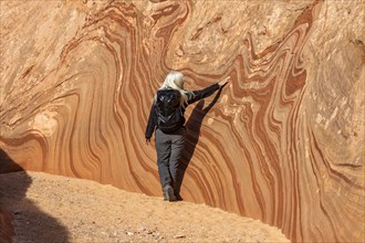 Senior hiker exploring sandstone cliff