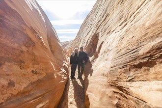 Senior hiker couple exploring slot canyon