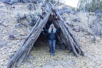 Senior female hiker standing in log shelter structure