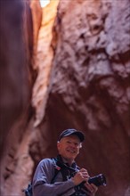 Senior male hiker with camera in canyon