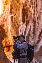 Senior hiker exploring and photographing rock formations in Kodachrome Basin State Park near Escalante Grand Staircase National Monument