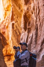 Senior hiker exploring and photographing rock formations in Kodachrome Basin State Park near Escalante Grand Staircase National Monument
