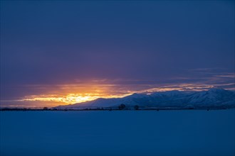 Sun rising above snowcapped mountains