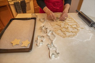 Woman baking Christmas cookies in kitchen