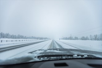 Snowstorm on highway seen from car