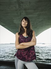 Portrait of woman in sleeveless top under bridge