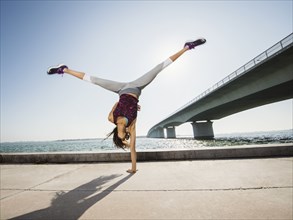 Woman performing handstand outdoors