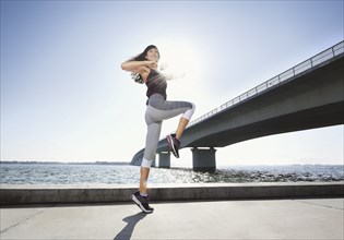 Woman exercising on riverbank