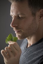 Close-up of man smelling fresh mint leaves