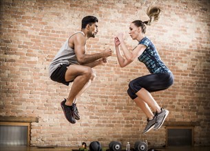 Man and woman jumping in gym