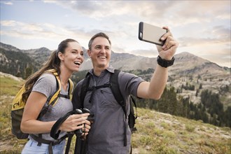 Hiking couple taking selfie in mountains