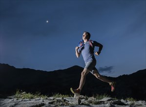 Man jogging in mountains at night