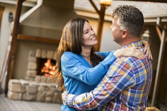 Mature couple dancing by fireplace