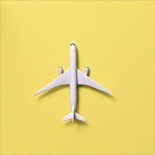 Overhead view of airplane model against yellow background