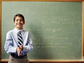 Portrait of boy (12-13) in front of chalkboard
