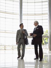 Two businessmen talking in lobby