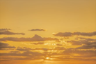 Golden clouds on sky at sunrise