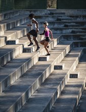 Man and woman jogging up steps