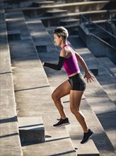Athletic woman with amputated hand running up steps
