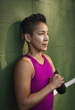 Athletic woman with amputated hand against wall