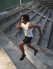 Athletic man running up steps