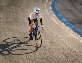 Athletic woman with amputated hand cycling on track