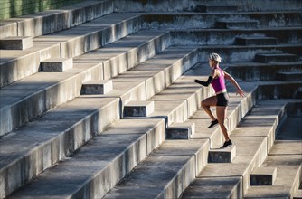 Athletic woman with amputated hand running up steps