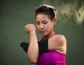 Athletic woman with amputated hand stretching arm