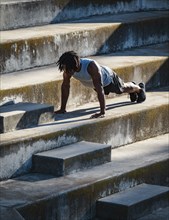Athletic man doing push-ups on steps