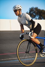 Athletic woman with prosthetic arm riding bicycle