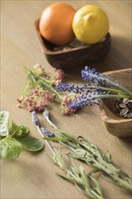Flowers, herbs and citurus fruit on wooden table