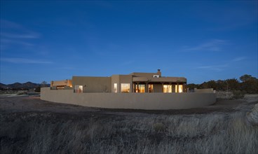 Pueblo style house in landscape at dusk