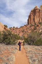 Female hiker photographing mesa in desert landscape