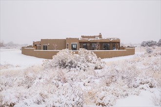 Pueblo style house in snow covered landscape