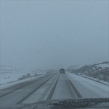 Snow covered rural road seen from car