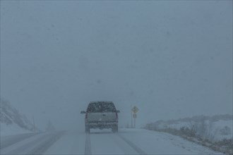 Pick-up truck on snow covered highway 20 in rural landscape