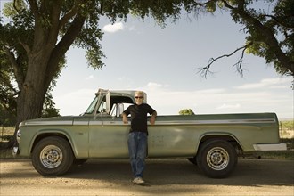 Man leaning on pick-up truck