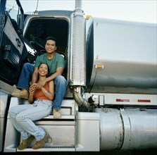 Couple sitting on doorsteps of truck