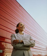 Businesswoman standing next to cargo container