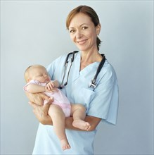 Portrait of doctor holding baby girl