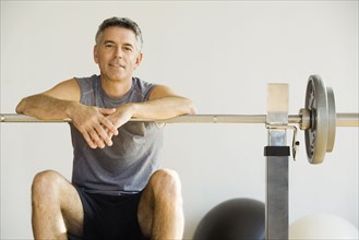 Portrait of man sitting on weight bench